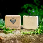 2 Louisa's Purifying Four Thieves Milk Soaps one wrapped in brown paper and one unwrapped on a stone slab with pieces of rosemary either side of the soaps