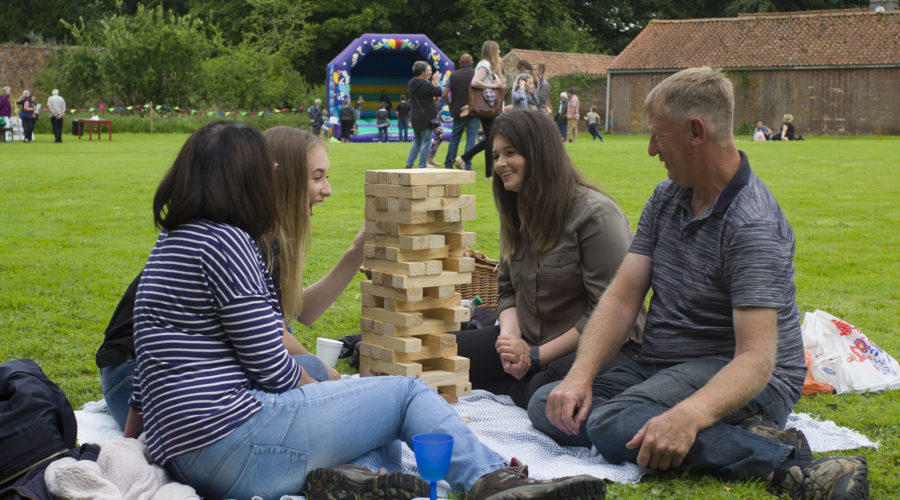 Four people playing giant jenga outside of South Ormsby Hall